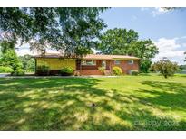 Charming brick home featuring a well-manicured lawn and mature landscaping at 615 Bell Farm Rd, Statesville, NC 28625