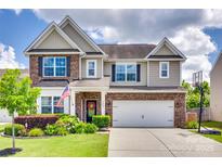 Charming two-story home with brick accents, a landscaped yard, and a two-car garage at 6243 Kilchurn Dr, Indian Land, SC 29707