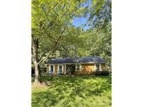 Charming home featuring a well-maintained yard, complemented by mature trees and quaint white shutters at 6832 Delta Lake Dr, Charlotte, NC 28215