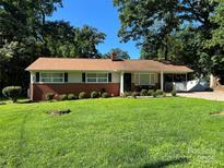 Charming one-story home with a brick facade, well-manicured lawn, and mature trees in a peaceful setting at 708 East St # 89, Albemarle, NC 28001