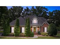 Charming brick home with a well-manicured lawn, mature trees, and a welcoming front porch at 803 Woodmoore Ln, Kannapolis, NC 28081