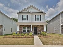 Charming two-story home featuring a brick facade, a covered porch, and black window shutters at 835 Windage Way, Pineville, NC 28134