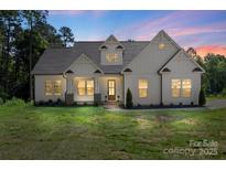 Charming home showcasing its architectural details and a beautiful manicured lawn in twilight at 8680 Sherrills Ford Rd, Sherrills Ford, NC 28673