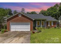 Charming brick home with a well-maintained lawn and attached garage at 9520 Marshbrooke Rd, Matthews, NC 28105
