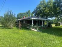 Charming brick home with a cozy front porch and lush green lawn at 10010 Stokes Ferry Rd, Gold Hill, NC 28071