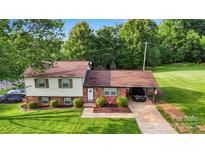 Charming split-level home with a well-manicured lawn, brick accents, and a convenient carport for parking at 103 Little Forest Ln, Statesville, NC 28625