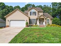Charming two-story home featuring a manicured front yard and a two-car garage at 1701 Whitney Ln, Salisbury, NC 28146