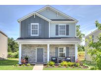 Charming two-story home with stone accents, inviting front porch, and well-maintained landscaping at 240 Orson Oaks Ln, Pineville, NC 28134