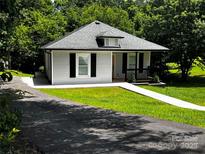 Charming bungalow with a well-manicured lawn and inviting front porch, perfect for enjoying the outdoors at 305 E Henry St, Belmont, NC 28012