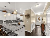 Bright eat-in kitchen features granite counters, stainless appliances, pendant lighting and dark hardwood floors at 515 Stickley Pl, Lancaster, SC 29720