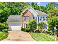 Charming two-story home featuring a well-manicured lawn, brick accents, and a two-car garage at 5238 Downing Creek Dr, Charlotte, NC 28269
