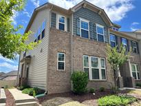 Beautiful townhome exterior with brick and siding, complemented by blue shutters and a well-manicured lawn at 5337 Orchid Bloom Dr, Indian Land, SC 29707