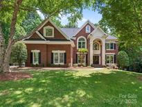 Beautiful brick home with a well-manicured lawn and mature trees, perfect for Gathering living at 610 Hampshire Hill Rd, Matthews, NC 28105