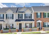 Charming townhome with white siding, black shutters, and a well-manicured lawn and picket fence at 764 Atherton Way, Rock Hill, SC 29730
