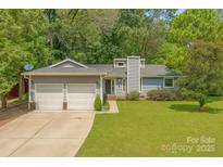 Charming single-story home with a well-maintained lawn and an attached two-car garage at 11834 Carmel Lakes Dr, Charlotte, NC 28226