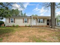 Charming single-story home featuring a covered front porch and neutral siding with decorative shutters at 120 Tower Dr, Statesville, NC 28677
