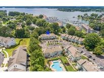 Beautiful aerial view of a condo community by the lake with a pool, green spaces, and boat harbor at 17431 Tuscany Ln, Cornelius, NC 28031