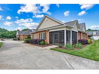 Charming brick home features a screened porch, well-maintained landscaping, and a concrete driveway at 2369 Stardust Ct, Denver, NC 28037