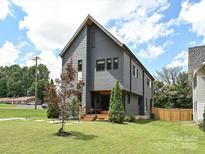 Two-story home showcasing modern architecture, gray siding, well-kept lawn, and landscaped front yard at 2553 Elkwood Cir, Charlotte, NC 28205