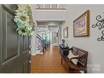 Inviting foyer boasts an open floor plan, wood floors, staircase, high ceilings and bench seating at 3020 Waxhaw Crossing Dr, Waxhaw, NC 28173