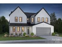 Charming two-story home featuring white painted brick, black window trim and a two car garage at 332 Linda Carol Ln, Tega Cay, SC 29708