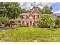 Charming two-story brick home featuring a well-manicured lawn and mature landscaping at 5610 Monticello Nw Dr, Concord, NC 28027