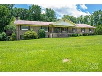 Charming brick home featuring a large front yard with mature trees and welcoming front porch at 5635 Highway 55 E Hwy, Clover, SC 29710