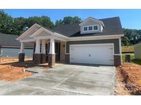 Charming one-story home featuring a covered porch and a two-car garage, complemented by stone and siding accents at 608 Banter Ln # 31, Cramerton, NC 28032