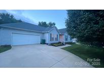 Charming home with a well-manicured lawn and a long driveway leading to an attached two-car garage at 614 W Peeler St, Salisbury, NC 28146
