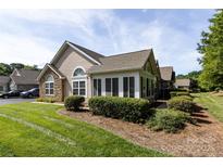 Attractive home exterior featuring stone accents, a well-maintained lawn, and manicured landscaping at 6811 Ledgestone Pl, Charlotte, NC 28227