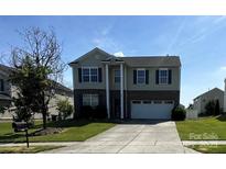 Charming two-story home featuring a manicured lawn and attached two-car garage at 1007 Green Terra Rd, Indian Trail, NC 28079