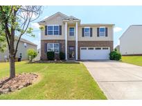 Charming two-story home with a well-manicured lawn and a two-car garage at 1007 Green Terra Rd, Indian Trail, NC 28079
