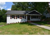 Charming one-story home featuring a well-manicured lawn, crisp white brick, and sidewalk at 1038 Holmes Ave, Salisbury, NC 28144