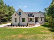 Charming white brick home with black trim, manicured lawn, and beautiful landscaping at 1062 Sage Pine Cir, Clover, SC 29710
