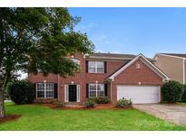 Charming two-story brick home with a well-manicured lawn and attached two-car garage at 11305 Erwin Ridge Ave, Charlotte, NC 28213