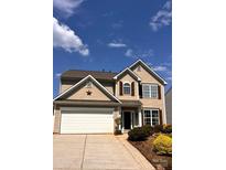 Charming two-story home featuring beige siding, a two-car garage, and a well-manicured front yard on a sunny day at 115 Morrocroft Ln, Mooresville, NC 28117