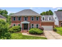 Charming two-story brick home with a well-manicured lawn and attractive landscaping at 12416 Stirling Trace Ct, Charlotte, NC 28277