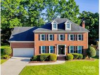Beautiful two-story brick home with manicured lawn, mature trees and traditional architectural details at 12434 Sylvan Oak Way, Charlotte, NC 28273