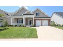 Charming home with a welcoming front porch, brick accents, and a well-manicured lawn at 14019 Cameryn Elise Dr, Cornelius, NC 28031