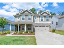 Charming two-story home boasts a manicured lawn, stone accents, and a two-car garage, creating a welcoming curb appeal at 1736 Rhynes Trl, Rock Hill, SC 29732