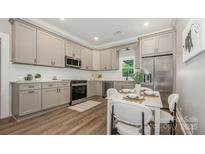 Beautiful kitchen with stainless steel appliances, white subway tile backsplash and breakfast nook at 201 Valley St, Stanley, NC 28164