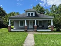 Charming single-story home featuring a covered porch with columns and well-maintained landscaping at 2417 Statesville Blvd, Salisbury, NC 28147