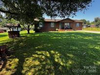 Charming single-story home with a well-maintained lawn, framed by a picturesque tree at 3375 Shepherd Rd, Maiden, NC 28650