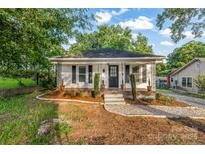 Charming single-story home with white siding, front porch, and landscaped front yard at 402 Ford St, Kannapolis, NC 28083