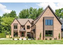 Stunning brick home with manicured lawn, professionally landscaped, and traditional architectural details at 412 Jefferson Dr, Charlotte, NC 28270