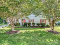 Charming home with a well-maintained front yard, lush lawn, mature trees, and an American flag at 4801 Pennant Pl, Charlotte, NC 28212