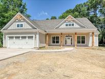 Charming single-story home featuring a two-car garage, covered porch with wooden pillars, and a neutral color scheme at 501 E Cj Thomas Rd # 1, Monroe, NC 28110
