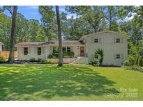 Charming two-story home with a well-maintained lawn and mature trees providing ample shade and curb appeal at 5611 Robinhood Rd, Charlotte, NC 28211