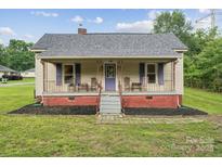 Charming single-story home with a cozy front porch, purple shutters and a landscaped yard at 626 Cabarrus W Ave, Concord, NC 28027