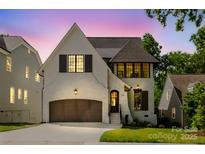 Beautiful two-story home featuring painted brick, dark shutters, and a three car garage at 705 Mcalway Rd, Charlotte, NC 28211